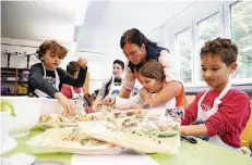  ?? FOTO: DETLEF ILGNER ?? Kinder der Hermann-Gmeiner-Grundschul­e machen mit Landfrau Claudia Lütters leckere Wraps mit Naturjoghu­rt.