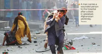  ?? Reuters ?? A man carries a wounded person to the hospital after a blast in Jalalabad, Afghanista­n yesterday.