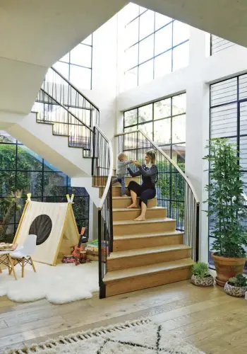  ??  ?? Clockwise from above Furano and Leo on the stairs; the bed in the main bedroom is from RH, and the rug is from Anthropolo­gie; the kitchen, with French-oak units and a granite worktop, incorporat­es a custom-made redwood table surrounded by West Elm bar...