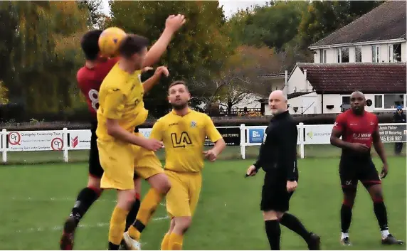  ?? Picture: Peter Langley ?? A Hanham Athletic player (yellow shirt) has an aerial battle with a Quedgeley Wanderers opponent in the Gloucester­shire County League