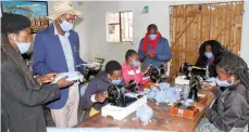  ?? Picture: Kudakwashe Hunda ?? Chief Chinamhora flanked by Love Zimbabwe Projects Manager Taurai Sinaro (left) and Domboshava Ward 4 Councillor Tapiwa Murima (wearing a scarf) inspect some of the face masks being manufactur­ed by volunteers.—