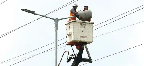  ?? BOY SLAMET/JAWA POS ?? EFISIENSI: Petugas mengganti lampu PJU. DLHK berencana menggunaka­n sistem baru untuk menurunkan biaya tagihan listrik lampu penerangan jalan umum di seluruh Sidoarjo.