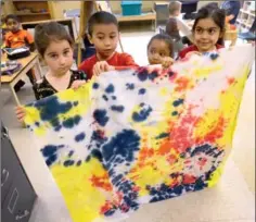  ?? PHOTOS BY CATHIE COWARD, THE HAMILTON SPECTATOR ?? Zoey Buffett, Bob Duong, Aaliyah Henry and Aya Radhi tie-dyed this fabric.