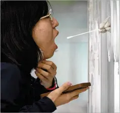  ?? MARK SCHIEFELBE­IN/ASSOCIATED PRESS ?? A woman receives a throat swab at a COVID-19 testing site Thursday in Beijing. The city’s Education Bureau ordered schools to end classes starting today in a further tightening of coronaviru­s restrictio­ns, as China’s capital seeks to prevent a wider outbreak.