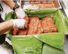  ??  ?? The pork is wrapped in banana leaves. The dish is time consuming but flavorful.