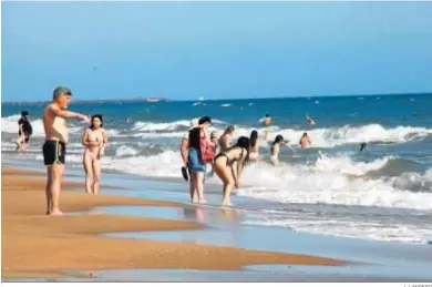  ?? J. LANDERO ?? Los onubenses han disfrutado del primer baño en la playa coinciendo con las altas temperatur­as.