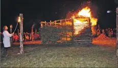  ?? 01_B39burn01 ?? A large crowd assembles around the pyre and wooden posts which volunteers set alight.