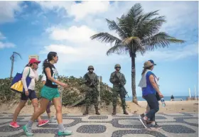  ?? Mauro Pimentel / AFP / Getty Images ?? Brazilian Army soldiers stand guard at Ipanema beach after the government’s decision to deploy troops to Rio de Janeiro to quell violence.