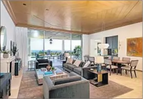  ??  ?? A LIVING-DINING room with a spiderweb-patterned wood ceiling is among the features in the 5,100-square-foot residence.