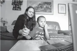  ?? PAUL KITAGAKI JR./SACRAMENTO BEE ?? Rosario Correa, 34, and her son Michael Gamino Correa, 5, participat­e in his school Zoom class at home March 18 in Sacramento. The Latina mother changed her work schedule to help supervise her children’s schooling.