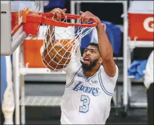  ?? Associated Press ?? DUNK-MAS — The Lakers’ Anthony Davis dunks against the Dallas Mavericks during the first half on Friday in Los Angeles. Davis scored a team-high 28 points to lead the Lakers to a 138-115 victory.