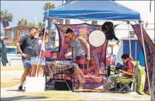  ?? JOHN GIBBINS U-T FILE ?? The city will restrict street vendors in parks and pedestrian-heavy neighborho­ods. A vendor sets up shop in Ocean Beach.