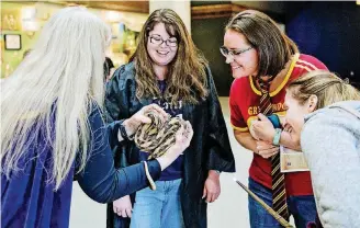  ?? [PHOTO PROVIDED] ?? Science Museum Oklahoma guests inspect a snake at the April SMO 21, an adults-only, after-hours event for ages 21 and older.