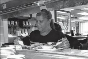  ?? Chicago Tribune/TNS/JAY JONES ?? The Four Way’s owner, Patrice Thompson, checks on orders during the Sunday lunchtime rush at her restaurant in Memphis. Thompson says King routinely stopped by for soul food when he was in town.