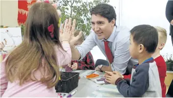  ?? JOHN WOODS/THE CANADIAN PRESS ?? Prime Minister Justin Trudeau meets with children at a YMCA-YWCA daycare centre in Winnipeg on Wednesday.