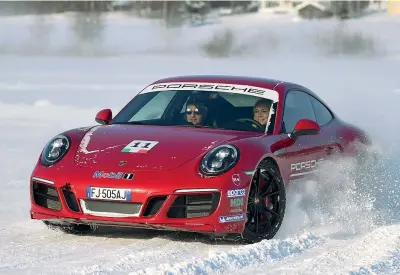  ??  ?? Una delle Porsche GTS impegnata sulla neve lappone. In alto, da sinistra: il «quartier generale» Porsche sul circuito ghiacciato, i cani da slitta e una suggestiva immagine notturna delle vetture (foto: Ludwig Eriksson, Producente­rna)