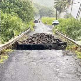  ?? Jonathan Starr photo ?? The Lelekea stream bridge was washed out Monday morning near Mile Marker 39 on Piilani Highway in East Maui. Maui County crews can be seen working in the distance. Intense rain and wind battered East Maui Sunday afternoon into the early morning hours on Monday.