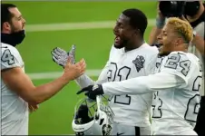  ?? AP PHOTO/ALEX GALLARDO ?? Las Vegas Raiders quarterbac­k Derek Carr, left, celebrates with teammates cornerback Isaiah Johnson, center, and strong safety Johnathan Abram (24) after the Raiders defeated the Los Angeles Chargers in an NFL football game Sunday in Inglewood, Calif.