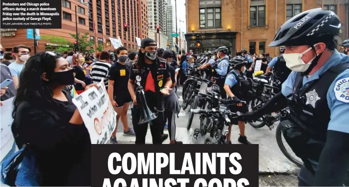  ?? TYLER LARIVIERE/SUN-TIMES FILE PHOTO ?? Protesters and Chicago police officers during a march downtown Friday over the death in Minneapoli­s police custody of George Floyd.