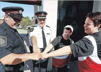  ?? CLIFFORD SKARSTEDT EXAMINER ?? Peterborou­gh Special Olympics athletes Crystal Cochrane and Shane Marshall share a few laughs with Const. Bill Trudeau and city police Chief Murray Rodd on Wednesday at the city police station.