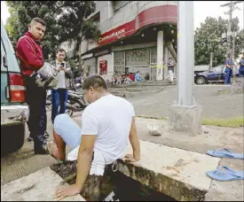  ?? BOY SANTOS ?? Police officers check a hole in the floor of a Chinabank branch in Quezon City yesterday after robbers dug a tunnel from a manhole (above photo) meters away from the bank over the weekend.