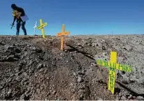  ?? Gregory Bull / Associated Press ?? Hugo Castro leaves crosses at the scene of the crash in Holtville, Calif., that killed 13 people Tuesday.
By Mustafa Salim and Louisa Loveluck