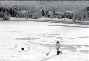  ?? Simonson Photo. ?? An ice angler keys in on an area adjacent to a steep bank. Noting changes in terrain around a water suggests what’s going on below and can lead to finding good starting points in both summer and winter on any lake or river.