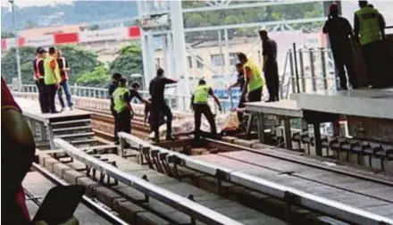  ??  ?? Police covering the body of a man who was fatally hit by a train near Pusat Bandar Puchong Light Rail Transit Station in Puchong yesterday.