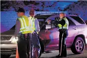  ?? LUIS SÁNCHEZ SATURNO/THE NEW MEXICAN ?? Officer Jacob Martinez talks to a driver Tuesday at a DWI checkpoint on Camino Carlos Rey. The checkpoint resulted in one arrest.