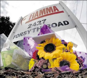  ?? JOE BURBANK / ORLANDO SENTINEL ?? A makeshift memorial is seen Tuesday beneath a roadside sign at Fiamma Inc., the site of Monday’s workplace shooting that killed five in Orlando.