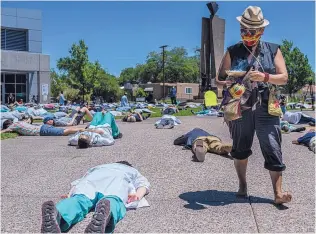  ?? ANTHONY JACKSON/JOURNAL ?? Caro Acuña smudges the air with burning copal during a die-in in front of the Health Sciences Library at the University of New Mexico’s North Campus on Thursday afternoon to protest racial disparitie­s in the medical field and to honor George Floyd.