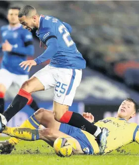  ??  ?? Brought to a halt Liam Gordon makes a sliding challenge on Kemar Roofe