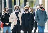  ?? CP PHOTO GRAHAM HUGHES ?? People wear face masks as they wait to cross a street in Montreal on Monday as the COVID-19 pandemic continues in Canada and around the world.
