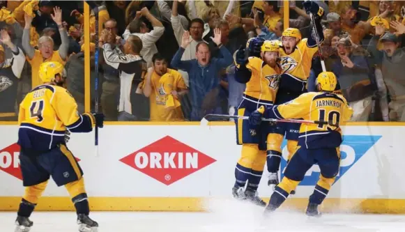  ?? FREDERICK BREEDON/GETTY IMAGES ?? Predators teammates celebrate with leaping Colton Sissons, the Game 6 hero with three goals to lift Nashville to victory and its first berth in the Stanley Cup final, starting next Monday.