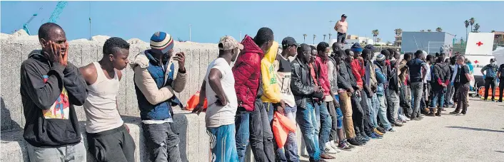  ??  ?? Afrikaner, die es nach Spanien geschafft haben: Im Hafen von Algeciras haben sie EU-Land unter den Füßen. Der Aktionspla­n der Union soll unkontroll­ierte Migration beenden.