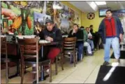  ?? ESTEBAN L. HERNANDEZ — NEW HAVEN REGISTER ?? The dining area of My Country Store is filled with patrons eating and watching a Spanish league soccer match on Jan. 28in East Haven. This part of the shop has been open for about a year and serves Latin cuisine.