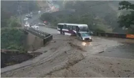  ?? JORGE CASTILLO ?? Dos fotos, un mismo sitio. La pequeña es del momento en que caía la lluvia que arrastró hacia el puente sobre el Virilla el material que se usa para ampliar la vía a tres carriles. Era tanto que el paso Santo Domingo-Tibás se bloqueó y hubo gente que pasó a pie.