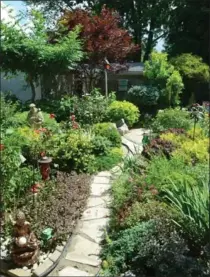  ??  ?? The garden is navigable via a quaint flagstone walkway which winds its way through the plants and flowers.