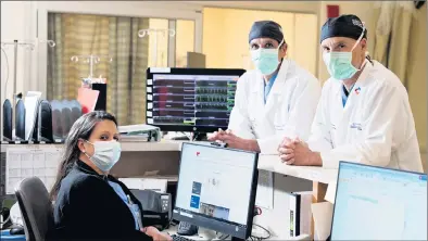  ?? ?? Dr. Robert Jumper, MD and Dr. David Lorenz, MD speak with a nurse following a procedure.