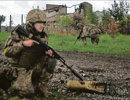  ?? Foto: ČTK ?? Na hlídce Ukrajinští vojáci patrolují ve znovudobyt­é vesnici u Charkova. I hromadný hrob s Čechem se našel na území, které ukrajinská armáda sebrala Rusům.