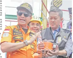  ?? — Reuters photo ?? Chief of National Search and Rescue Agency Muhammad Syaugi (left) shows part of the black box of Lion Air’s flight JT610 airplane, on Baruna Jaya ship, in the north sea of Karawang, Indonesia.