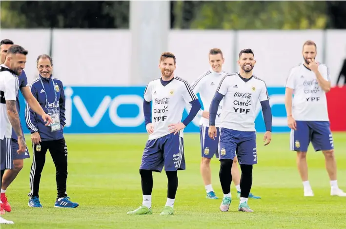  ?? JUANO TESONE ?? Ante todo, un buen clima interno. Sonríen Messi y Agüero en primer plano durante un entrenamie­nto. El plantel muestra una convivenci­a alegre en un lugar muy cómodo.