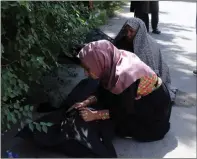  ??  ?? A woman tries to identify a body at a hospital in Kabul