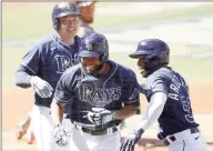  ?? Ezra Shaw / Getty Images ?? The Rays’ Manuel Margot, center, is congratula­ted by Ji-Man Choi, left, and Randy Arozarena after hitting a three-run home run against the Houston Astros during the first inning Game 2 of the ALCS on Monday in San Diego.