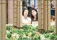  ?? SUPPLIED/CHINA DAILY ?? Customers gaze at real estate models at a property firm in China’s Hebei province.