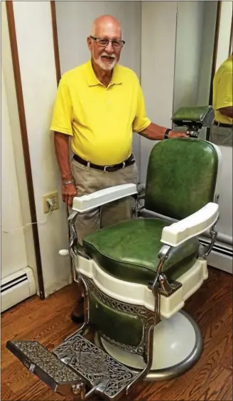  ?? DONNA ROVINS — DIGITAL FIRST MEDIA ?? Neil Gazzillo, owner of Spat and Slipper on Charlotte Street in Pottstown, stands with a barber’s chair from the 1930s. After 55 years spent as a barber, Gazzillo is retiring and selling his business. He expects settlement by Sept. 15.