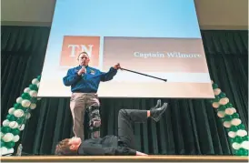  ?? YALONDA M. JAMES, THE COMMERCIAL APPEAL ?? NASA astronaut Barry Wilmore talks to students as junior James Potts, 16, demonstrat­es how Wilmore sits in a space shuttle during a visit to White Station Middle School on Thursday.