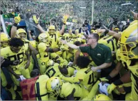  ?? THOMAS BOYD — THE ASSOCIATED PRESS ?? Oregon running back CJ Verdell (34), reaches out to a fan after scoring the winning touchdown in overtime to upend Washington, 30-27, Saturday.