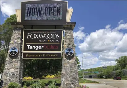  ?? Susan haigh / aP ?? NOT WAITING ANYMORE: A sign at the entrance to the Foxwoods Resort Casino, in Mashantuck­et, Conn., announces its reopening on Monday. Both tribal casinos, Foxwoods and Mohegan Sun, were closed since March 17, but opened despite opposition from Gov. Ned Lamont, who has limited power regarding the sovereign nations.