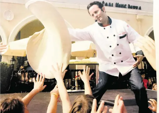  ?? Courtesy of Tony Gemignani ?? Tony Gemignani tossing pizza for a crowd of children in Boca Raton, Fla., in 2008.